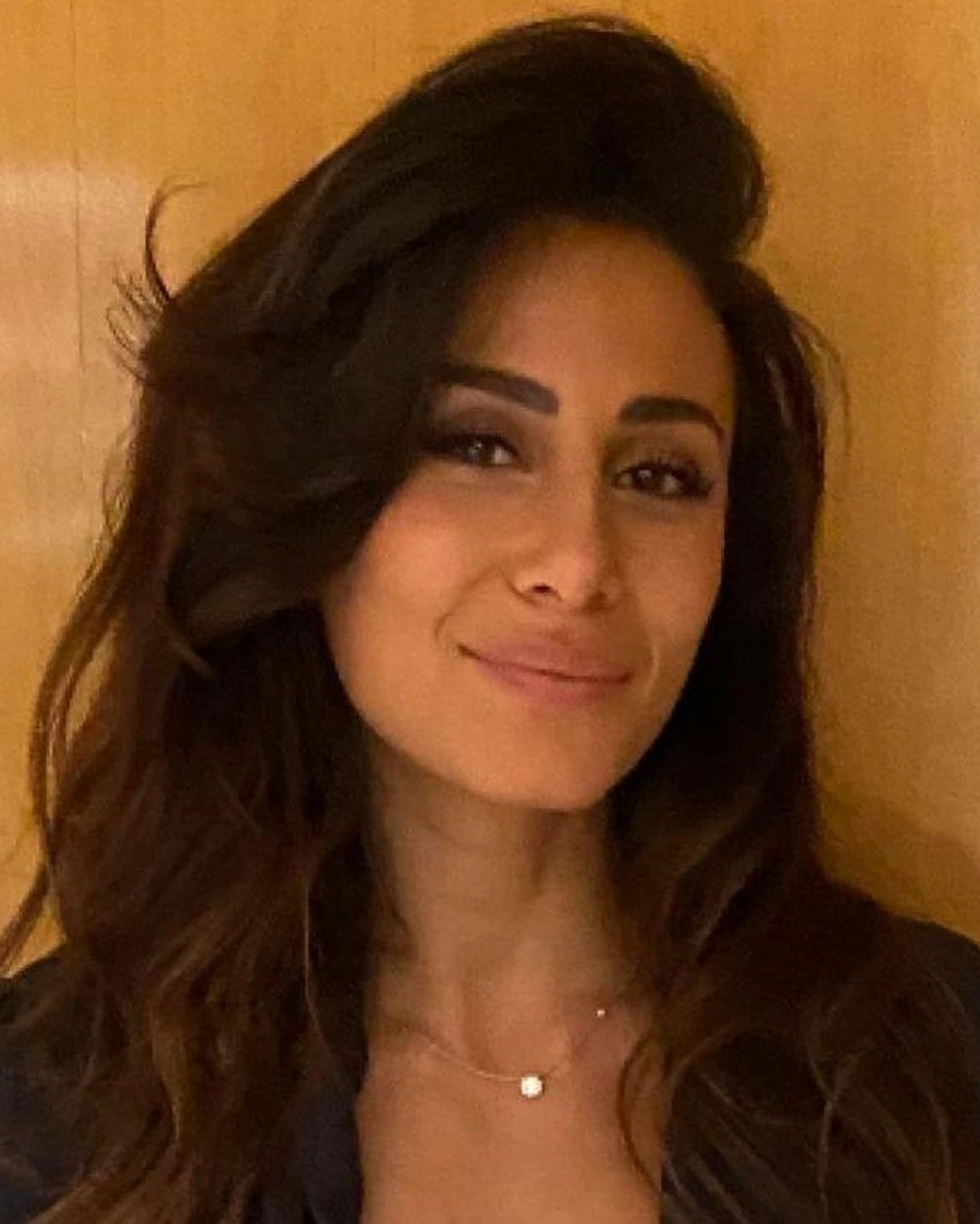 Dr. Laura Ismail smiling against a wood-paneled wall