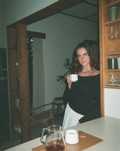 Kailee Sapphire holding a mug in a doorway, smiling