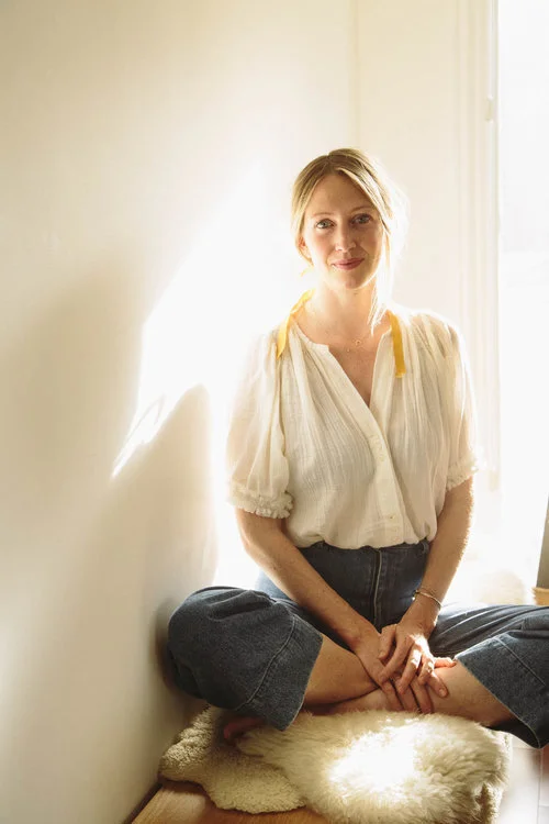 Lara Elliott seated cross-legged in warm sunlight