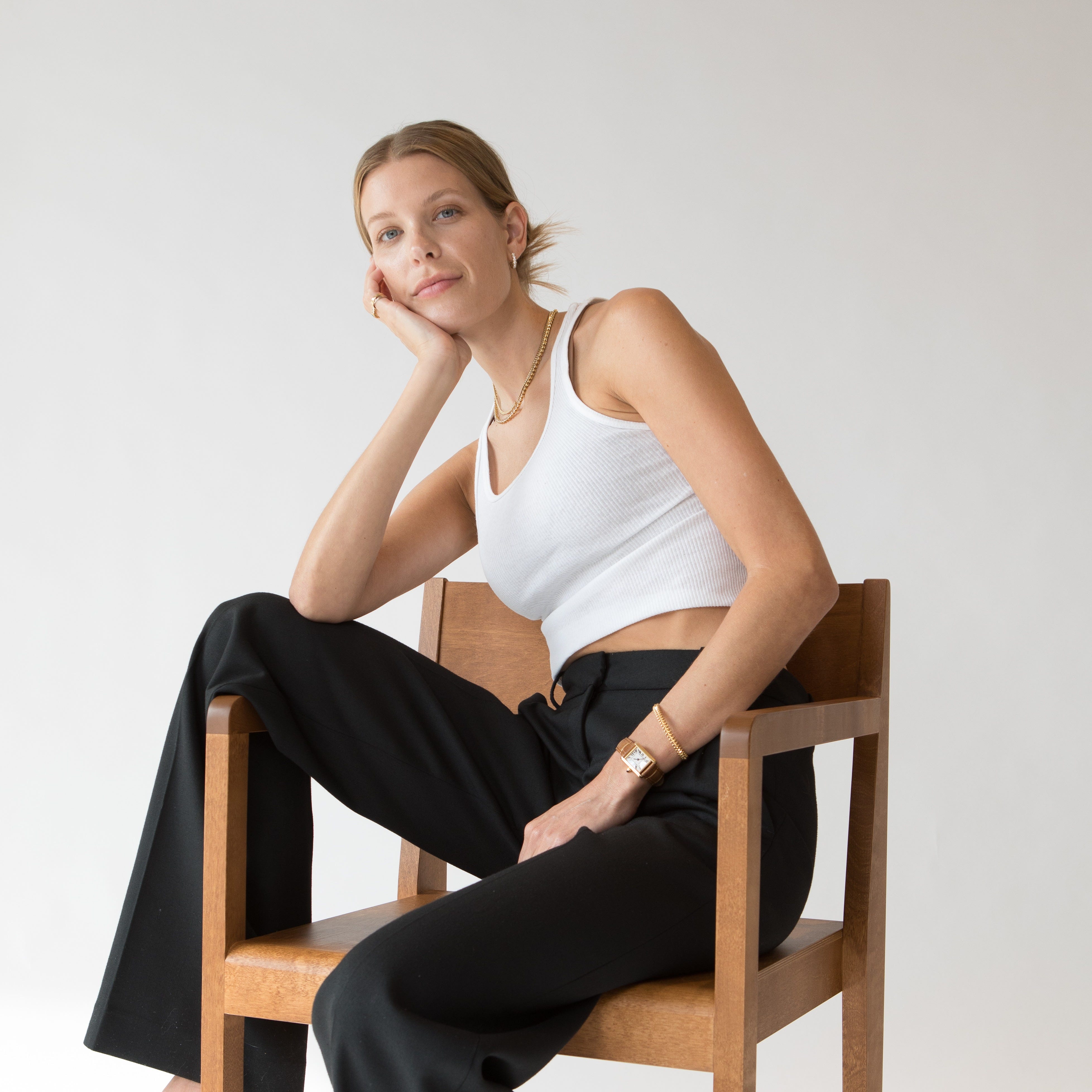 Nastazia Stolberg seated on a wooden chair in a studio setting