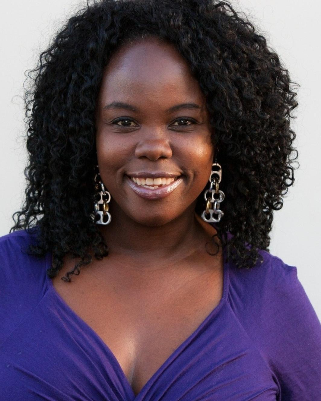 Tracy Piper smiling outdoors against a white wall